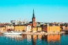 White boat on water near city buildings during daytime